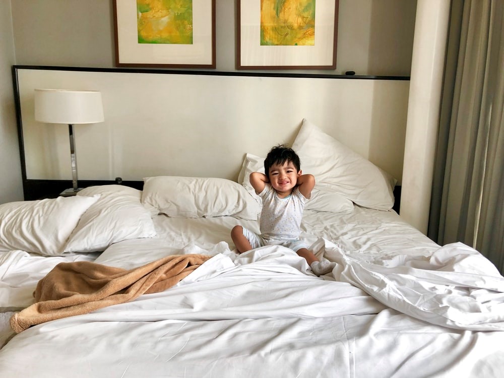 woman in white long sleeve shirt lying on bed